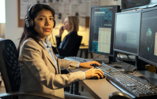 Woman in headset working with multiple desktop monitors