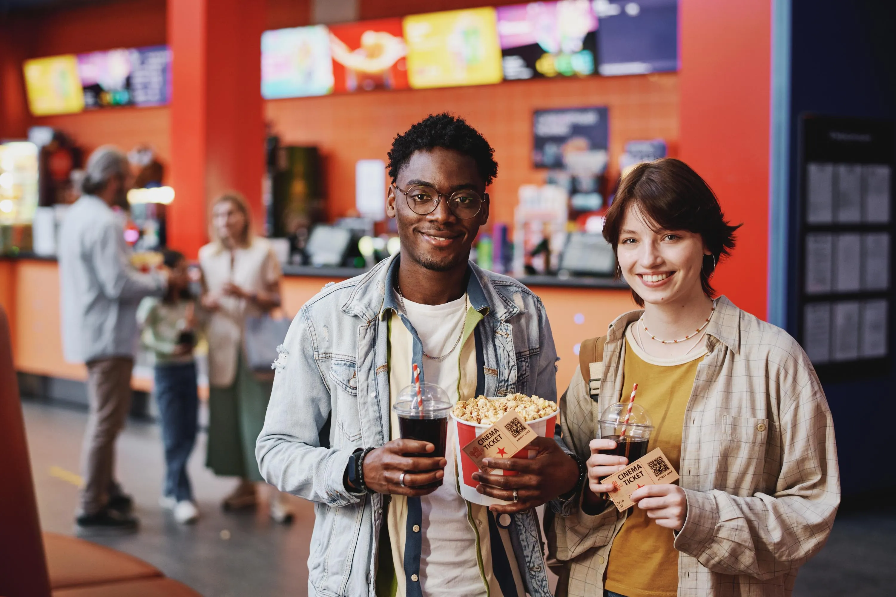 couple at concession holding tickets popcorn bucket and drinks