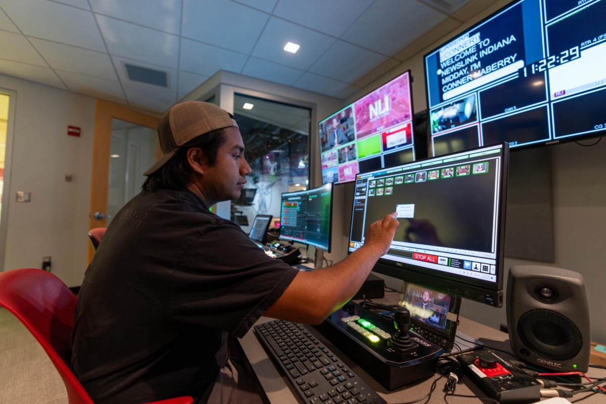 man broadcast control room at the production console