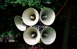 Cluster of megaphones on a stand in a park setting