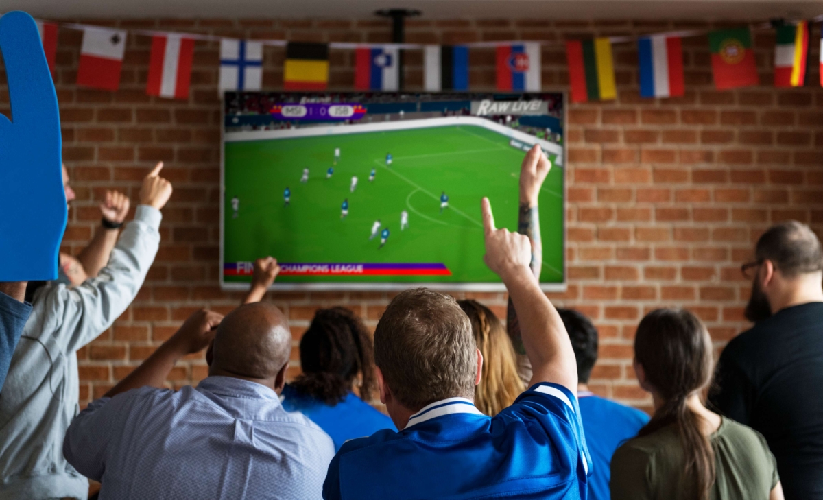 friends cheering at bar together seeing at the TV