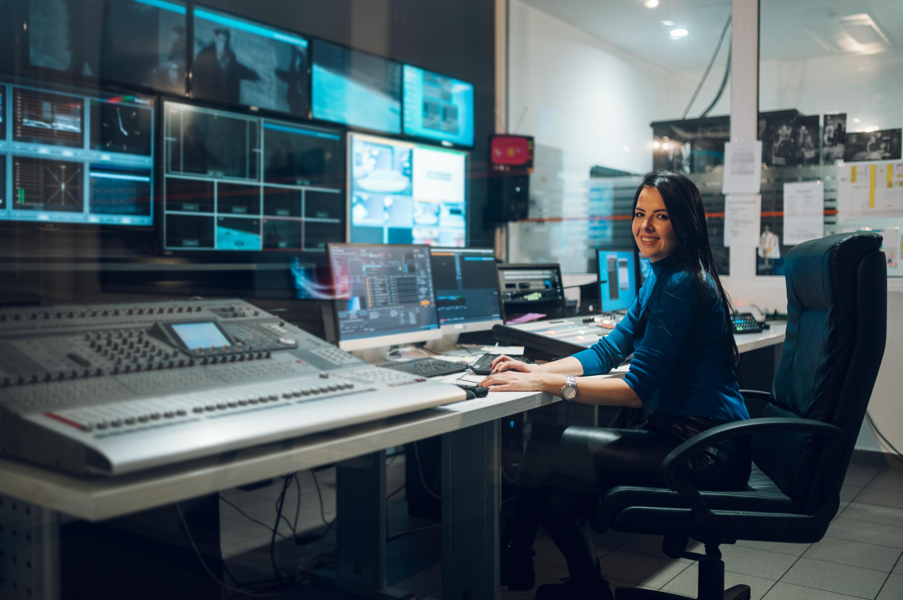 Middle aged woman using equipment in control room
