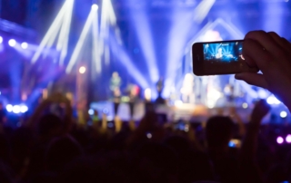 Fan taking photo in phone at concert