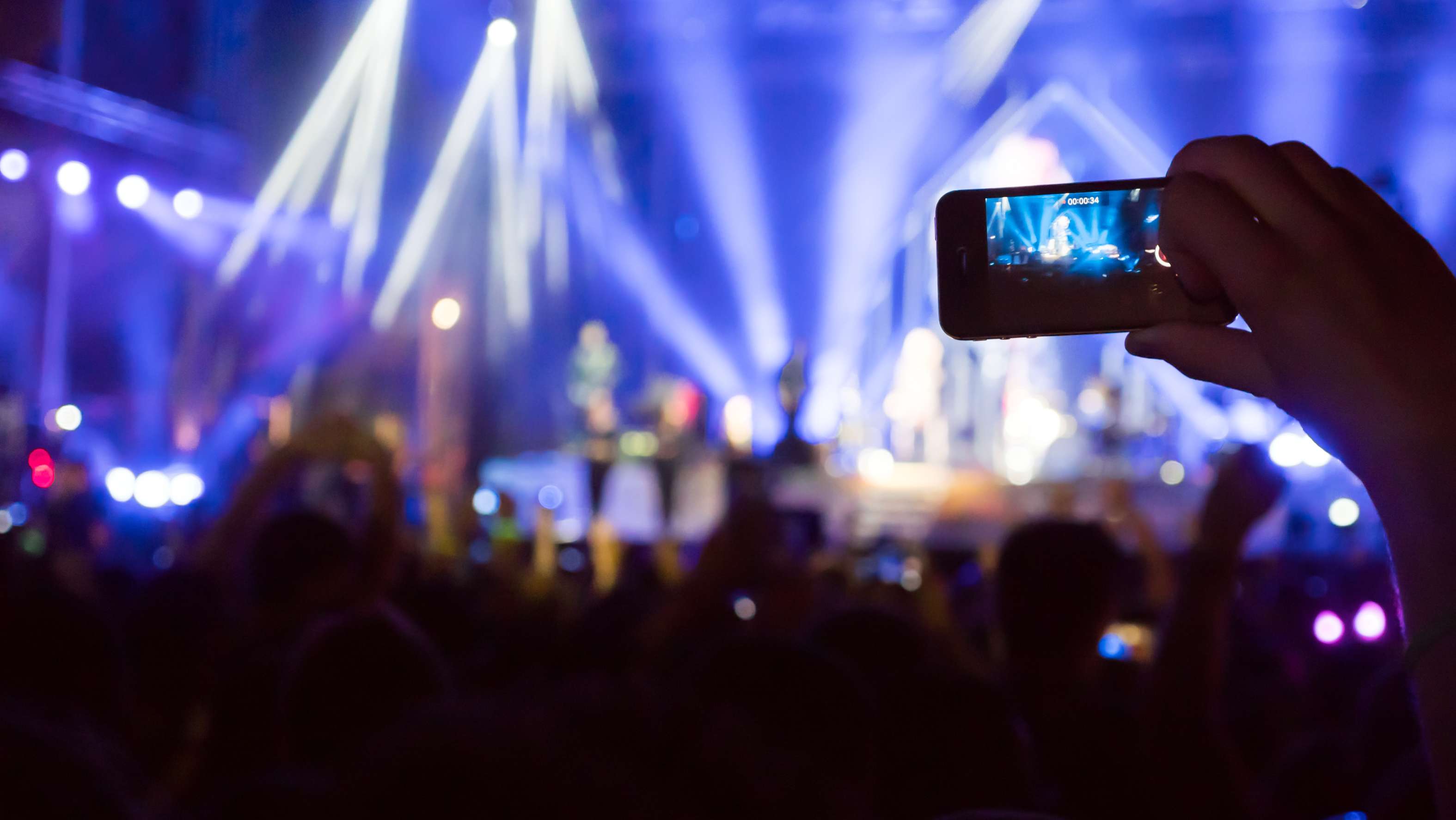 Fan taking photo in phone at concert
