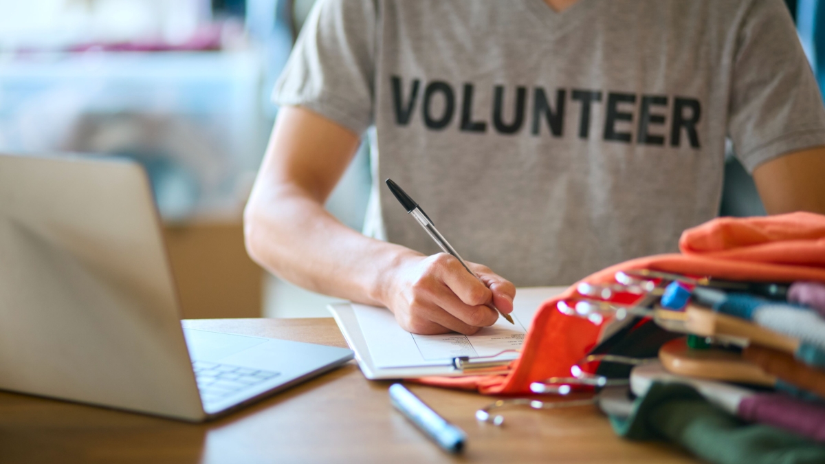 Close up male charity worker at desk with laptop